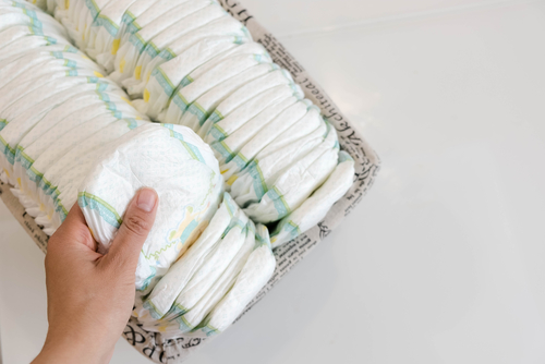Stack,Of,Baby,Disposable,Diapers,And,Pacifier,Over,White,Background